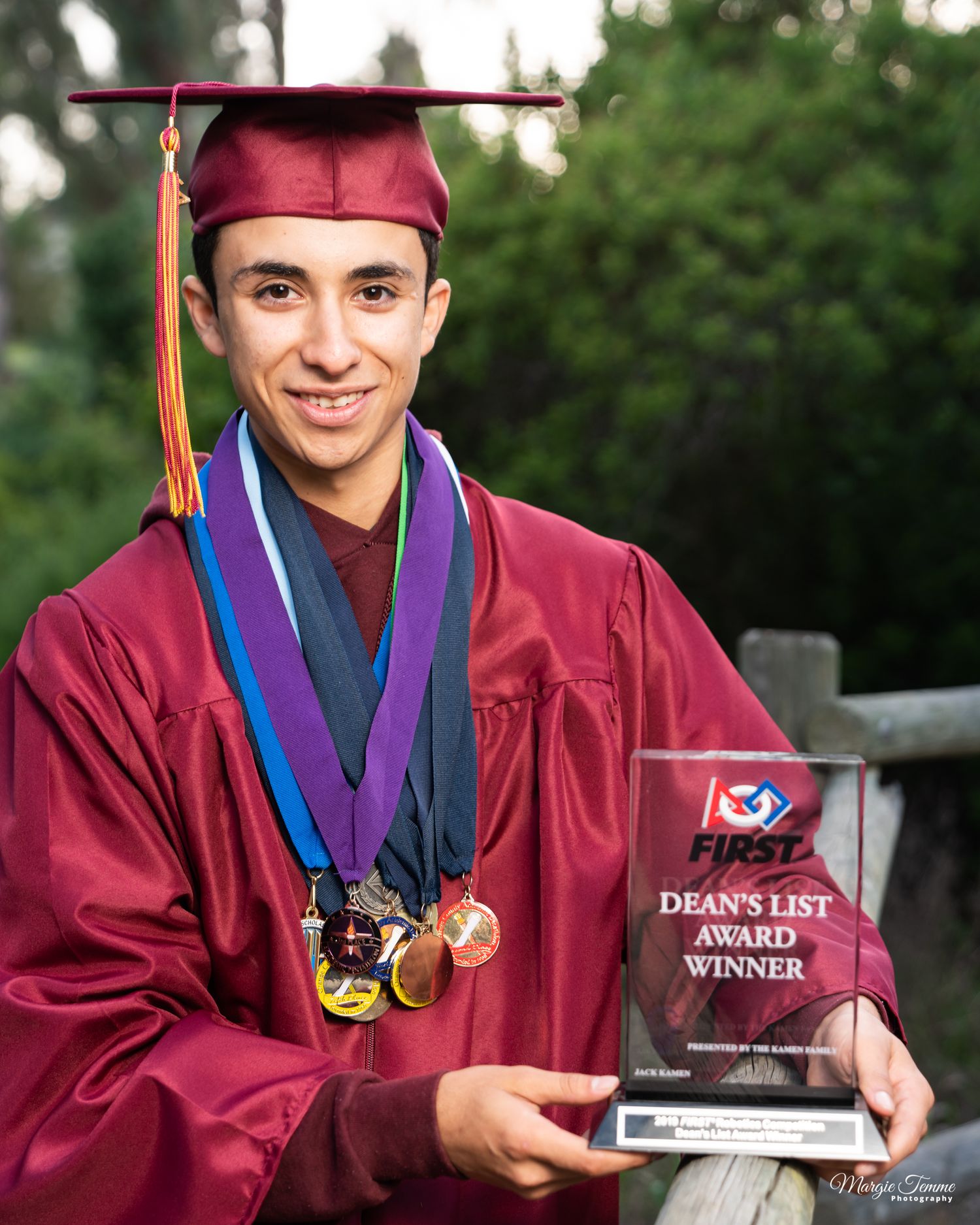 senior-boy-holding-award-wearing-metals-for-excellece-in-education-MIT