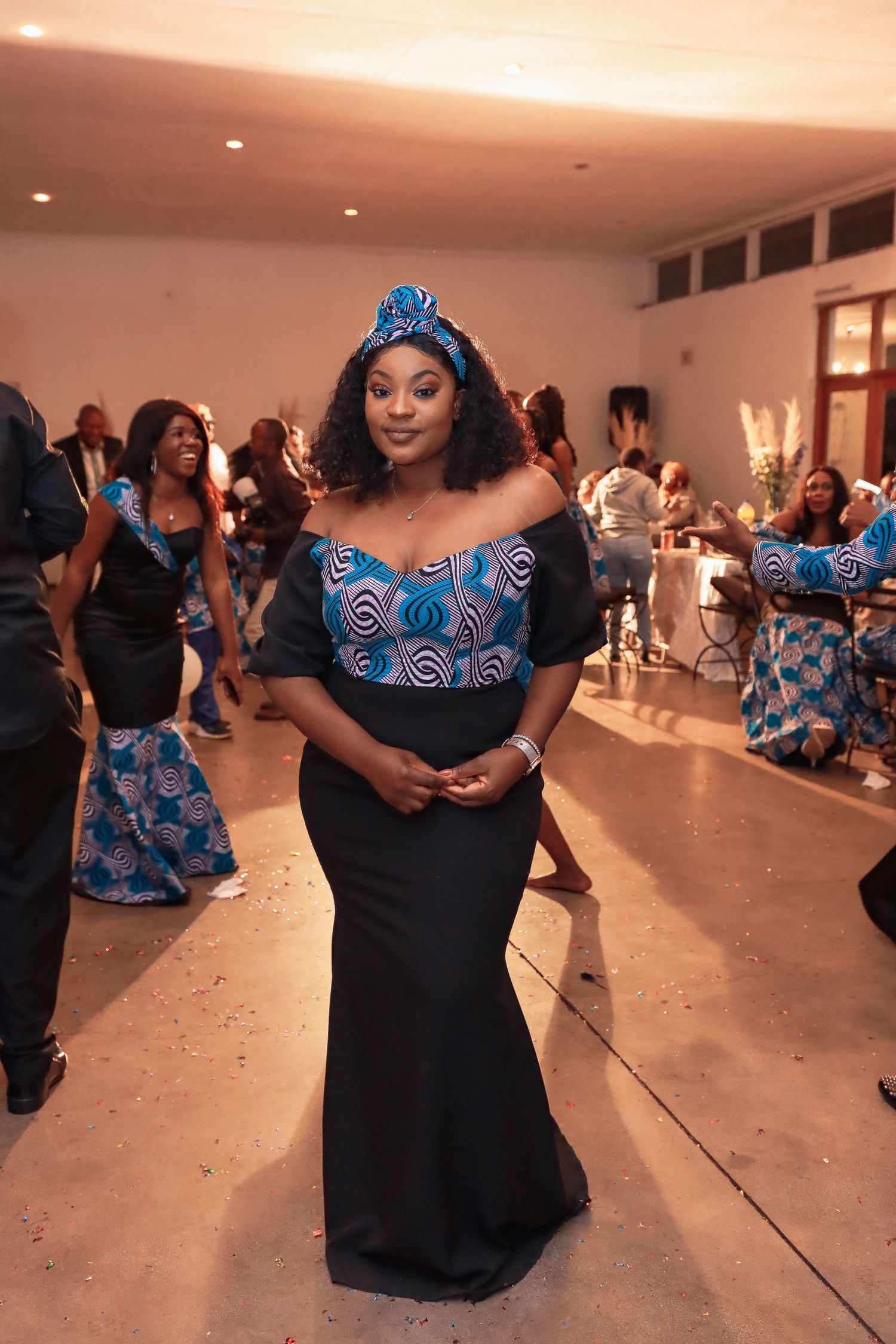 Cultural celebration featuring traditional African print formal wear at indoor event.