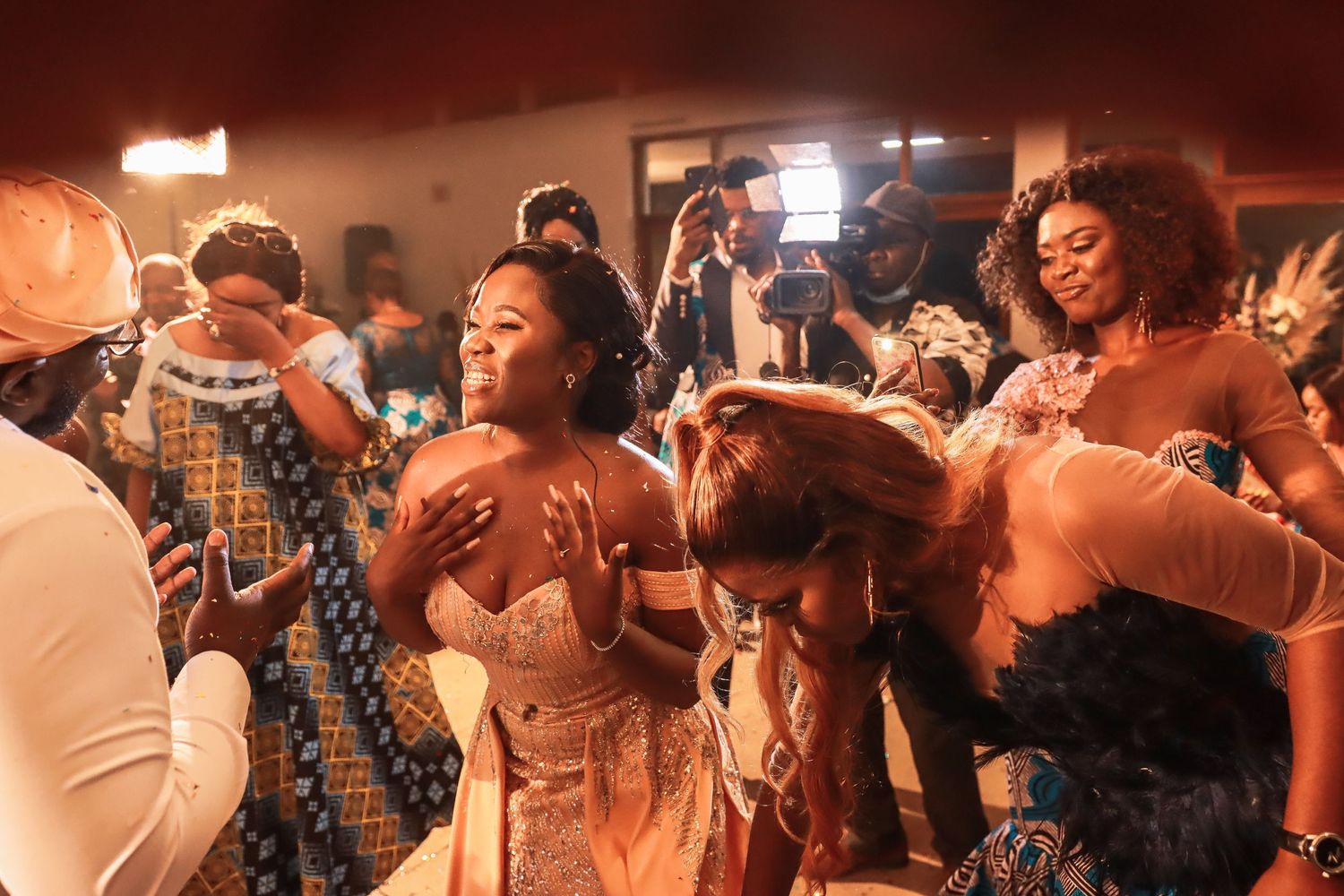 Energetic party scene with dancers in African-inspired clothing enjoying a celebration.