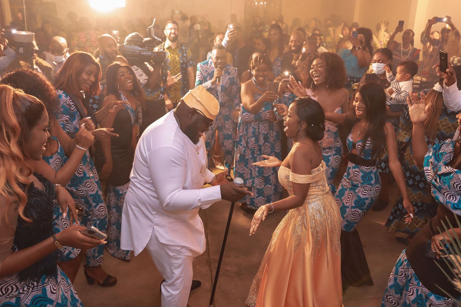Wedding celebration with dancers in traditional African print attire during a reception.