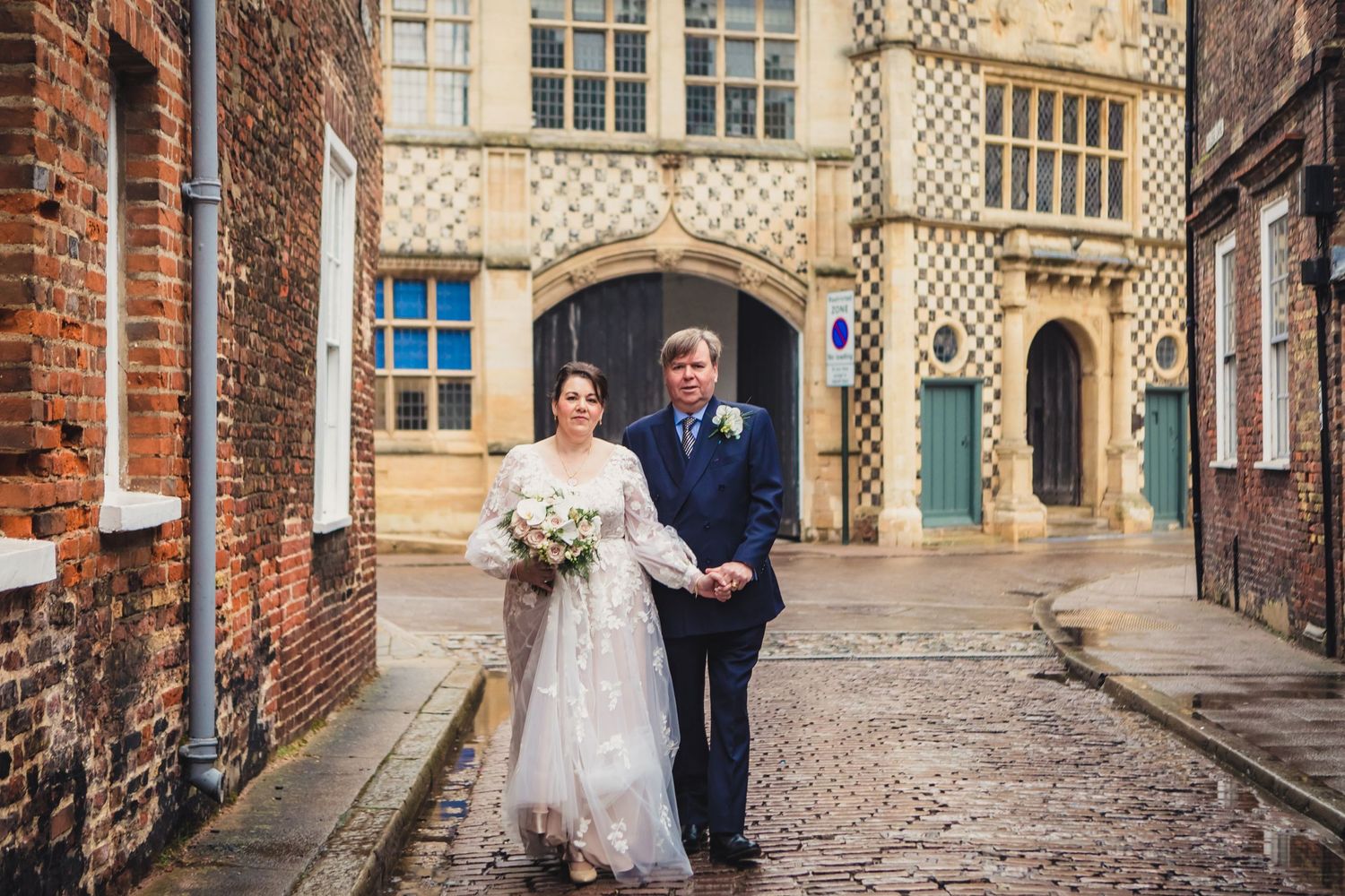 bride and groom walking together through kings Lynn cobbled streets