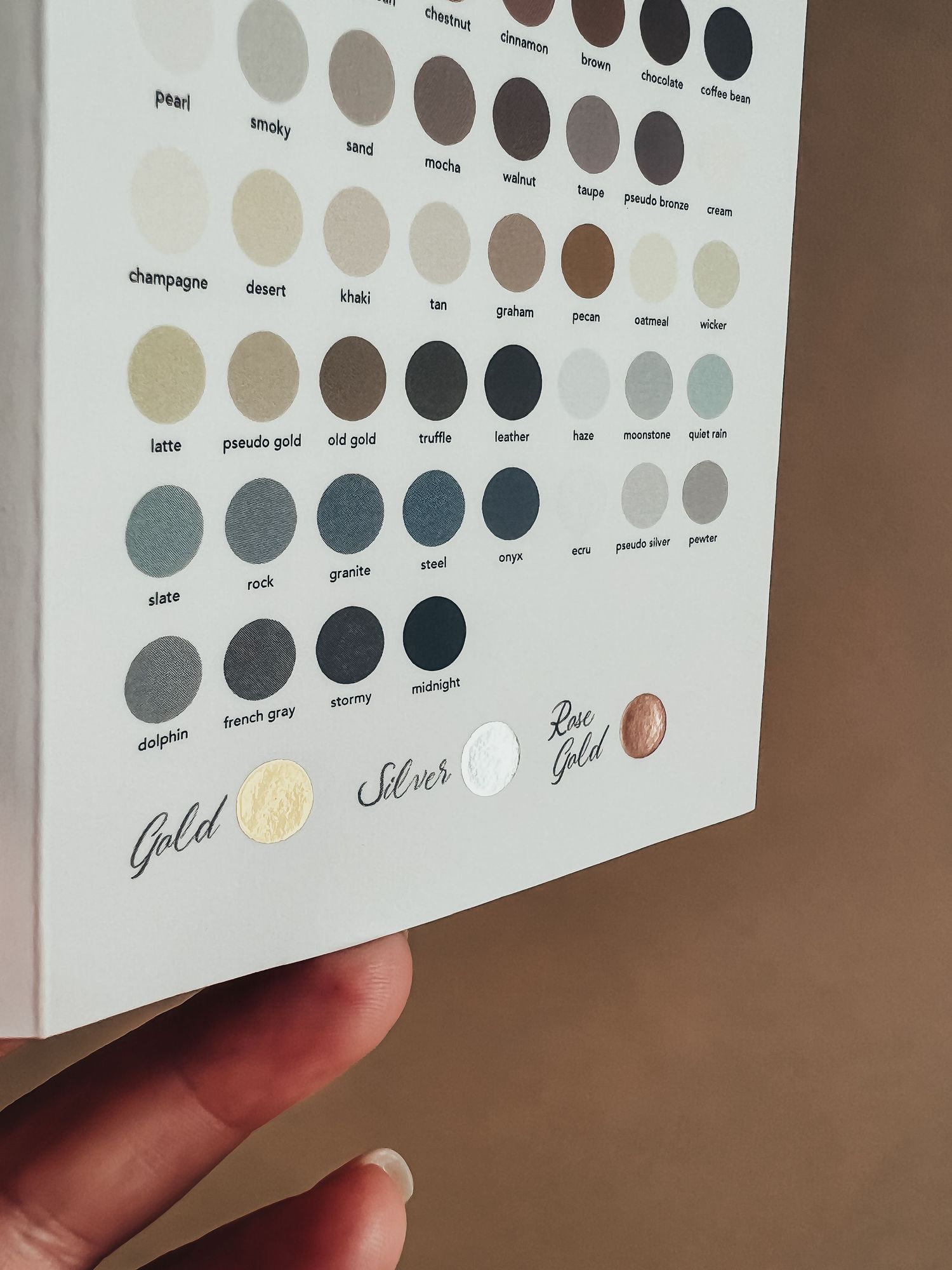 hand holding up the color pamphlet from Basic Invite showing the foil color options available