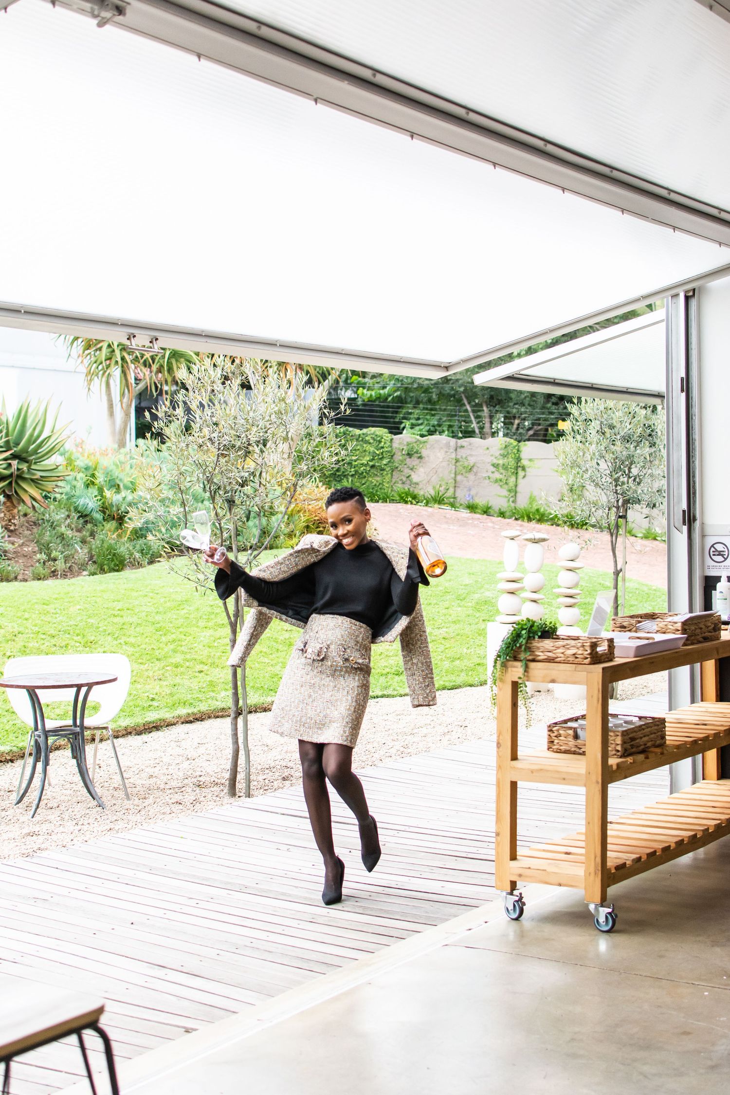 Joyful indoor-outdoor lifestyle photo showing movement and dancing on a wooden deck.