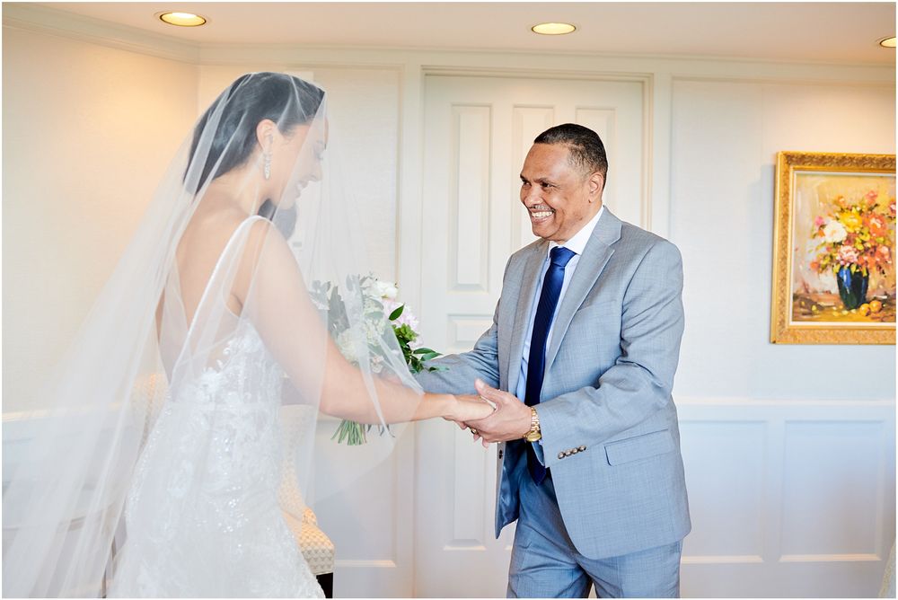 Emotional first look moment between bride and family member in bright indoor setting.