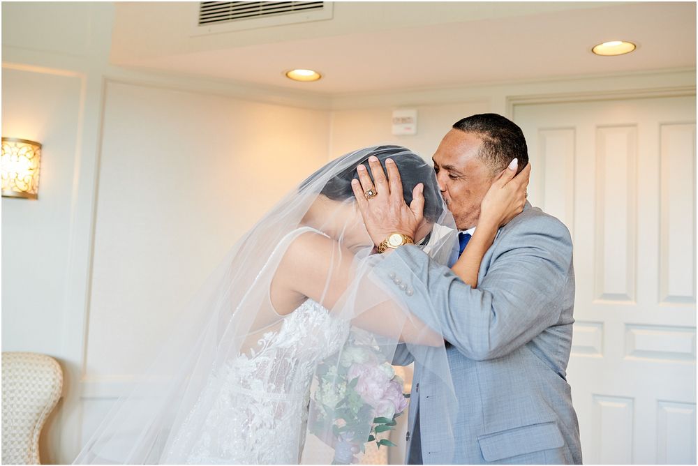 A joyful reaction during a wedding first look in an elegant white room.