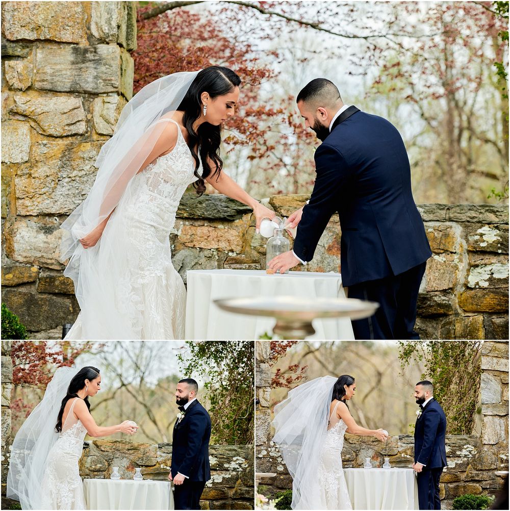 Wedding couple signing documents during outdoor ceremony against stone wall backdrop.