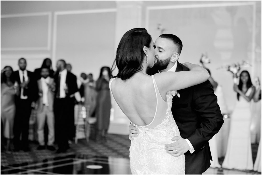 Black and white photo captures intimate dance moment at wedding reception.