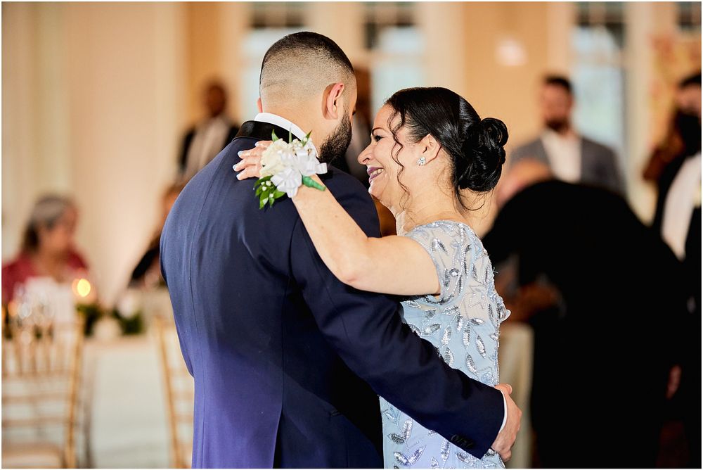 A tender moment shared during a mother-son dance at an elegant wedding reception.