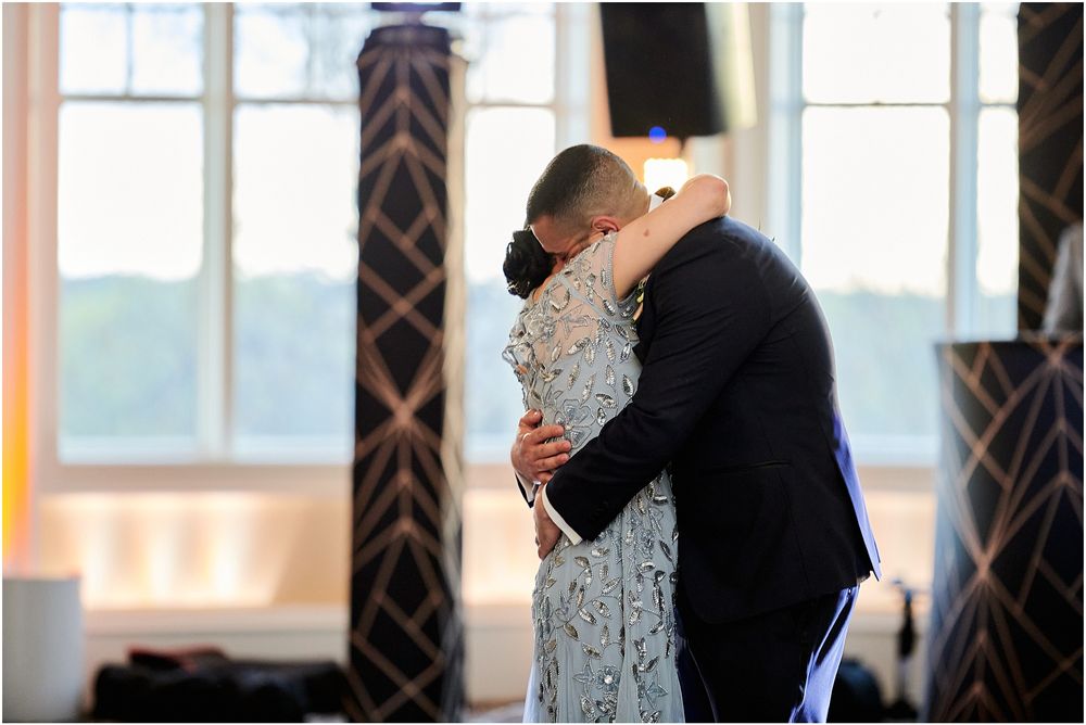 An intimate dance captured in silhouette against bright windows in an elegant reception venue.
