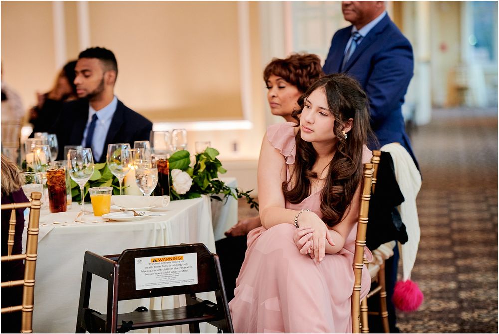 Wedding reception guests enjoying the celebration at tables with elegant place settings.