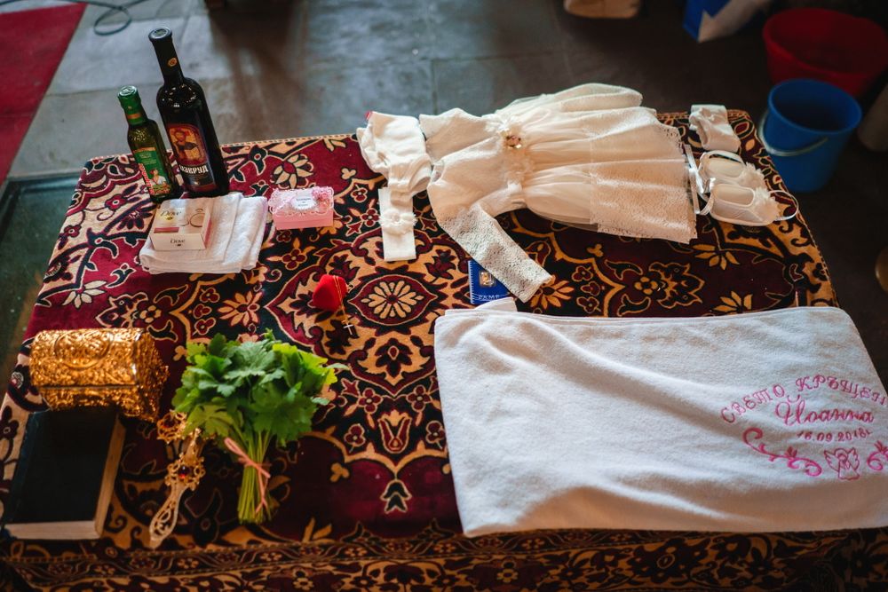 Table setting with colorful patterned tablecloth, white clothing items and decorative elements.