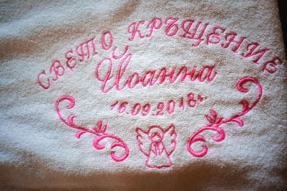 Pink embroidered text and decorative design in Cyrillic on white fabric dated 10.09.2019.