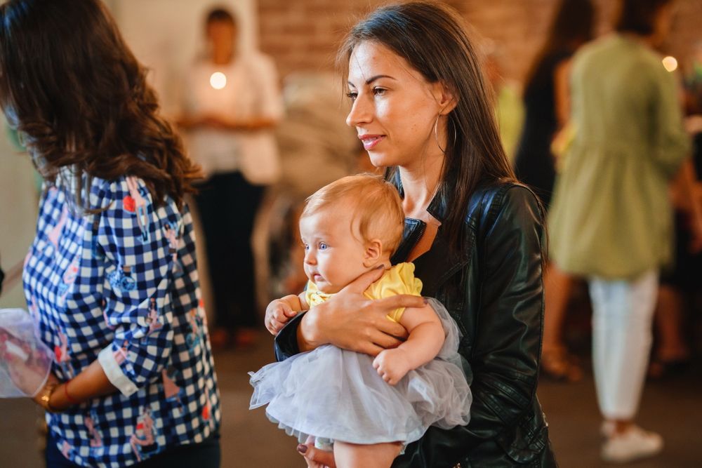 Interior scene at a baptism ceremony with people gathered in a brick-walled church.
