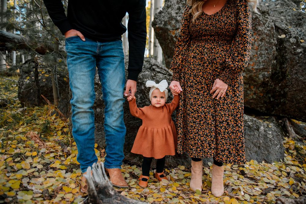 Family portrait session with rustic autumn styling in aspen forest setting.