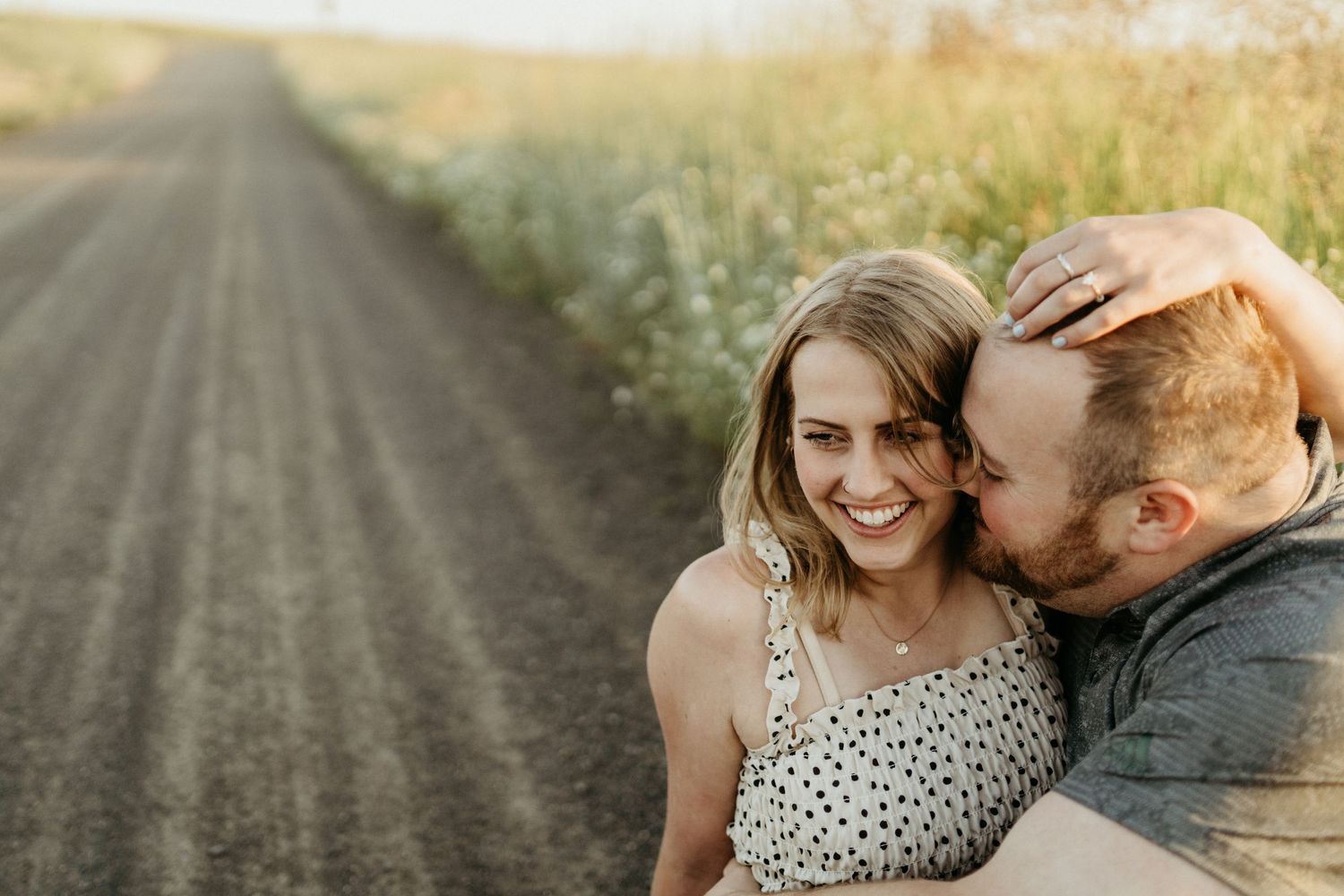 A tender moment captured on a rural dirt road during golden hour.