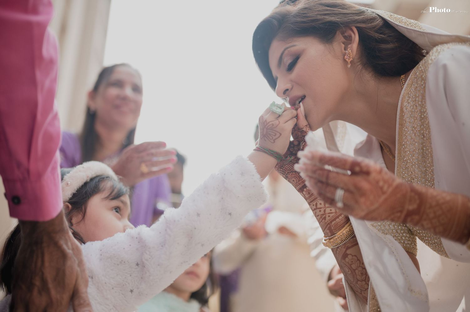 Wedding party members share joyful moments during indoor celebration.