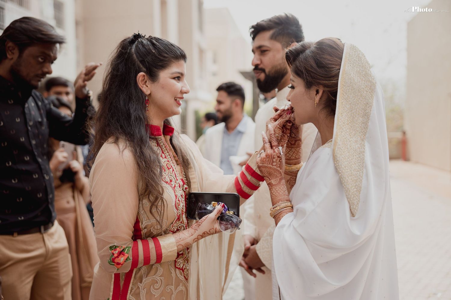 Wedding celebration with guests sharing laughter and joy in an indoor venue.
