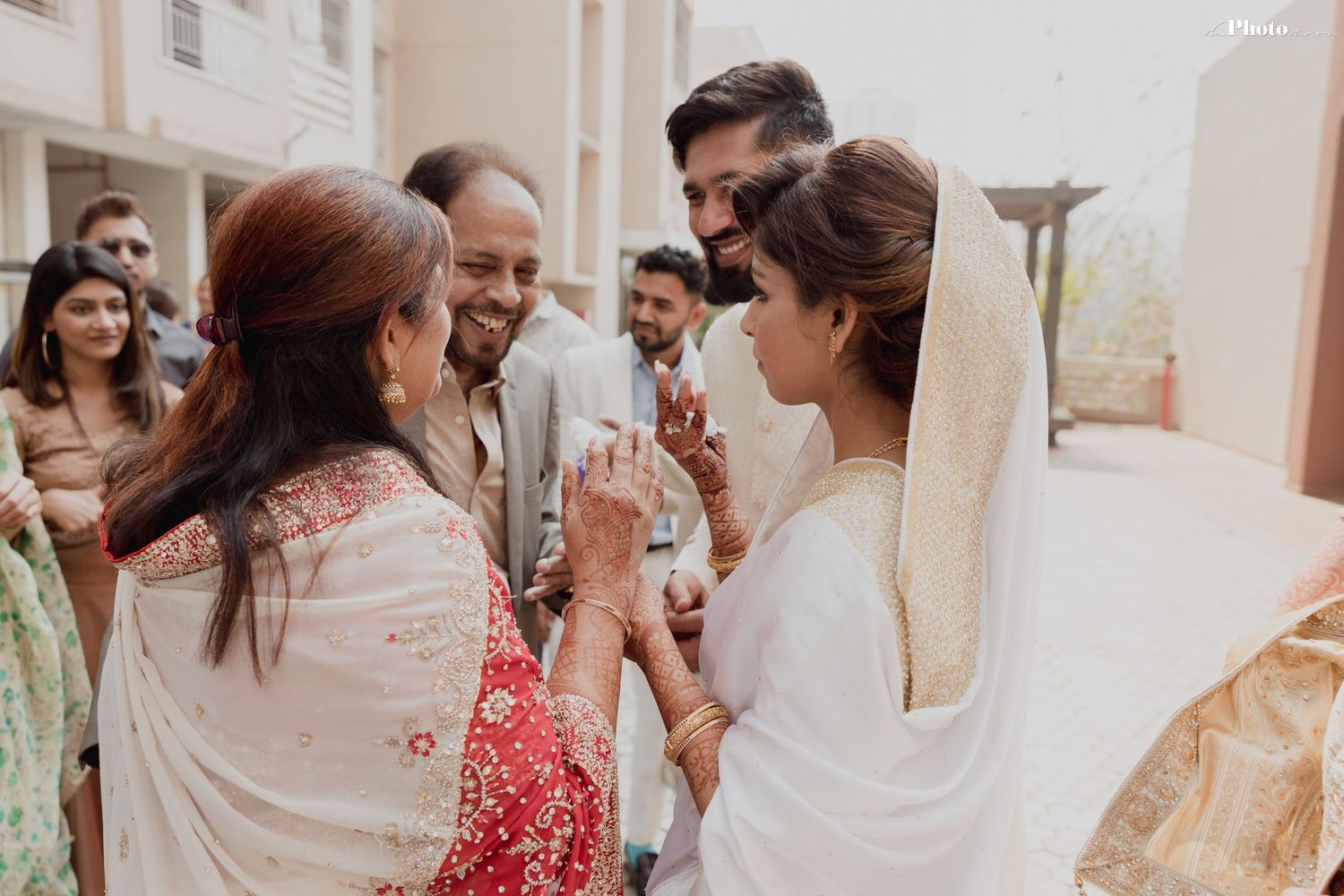 Festive indoor wedding celebration with guests in traditional attire.