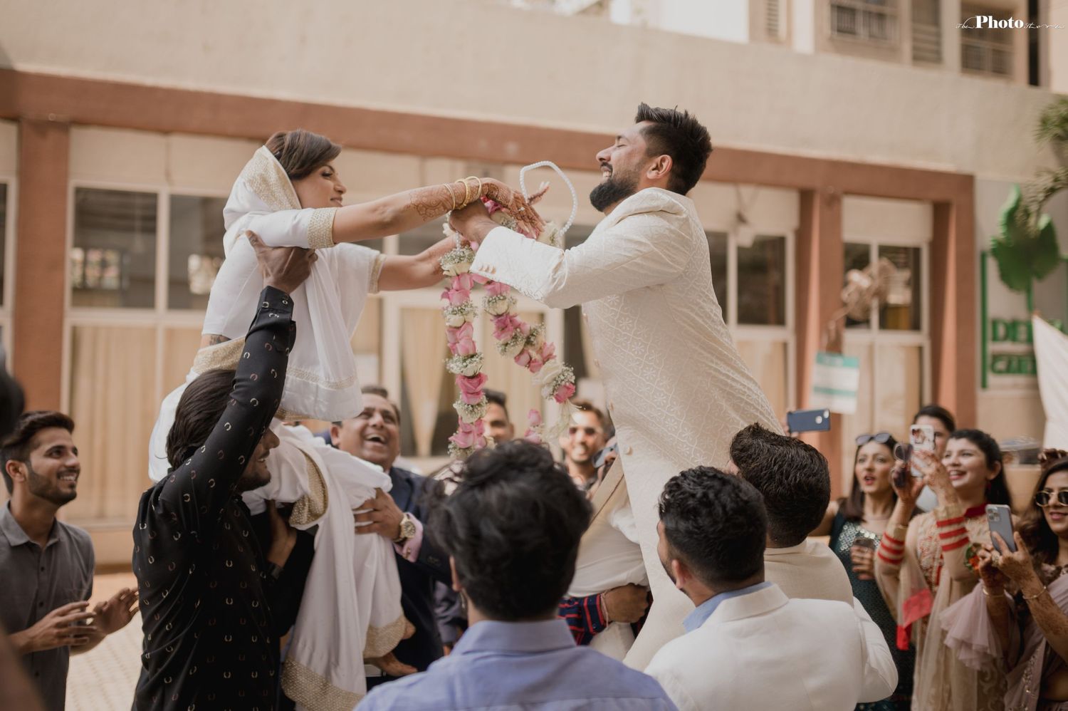 Wedding guests throw confetti in celebration during indoor reception.