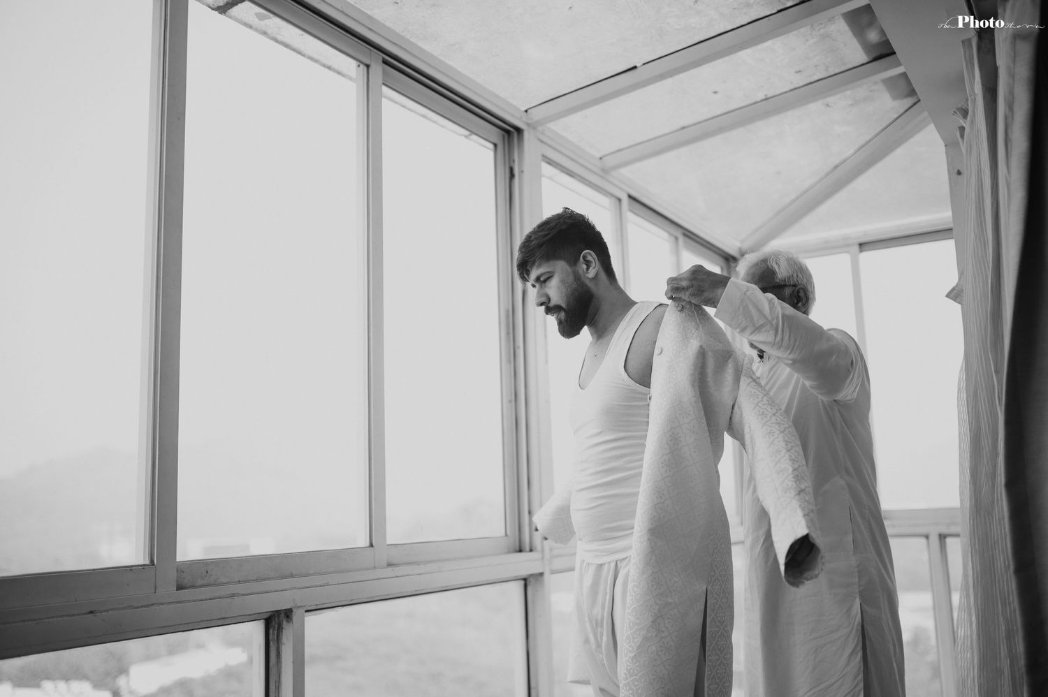 Black and white getting ready photo showing final wedding preparations.