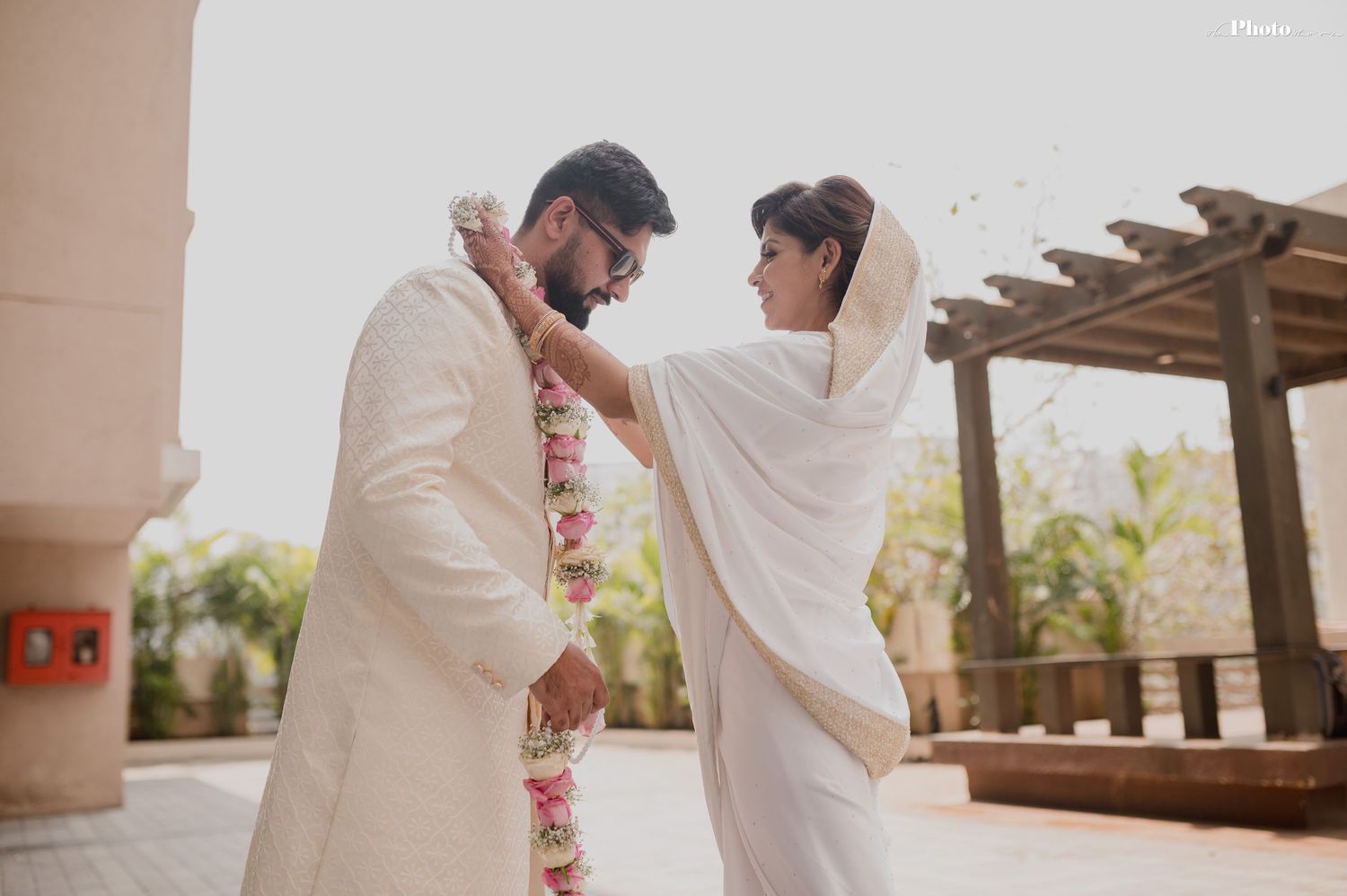 Elegant outdoor wedding ceremony with couple in traditional white attire.