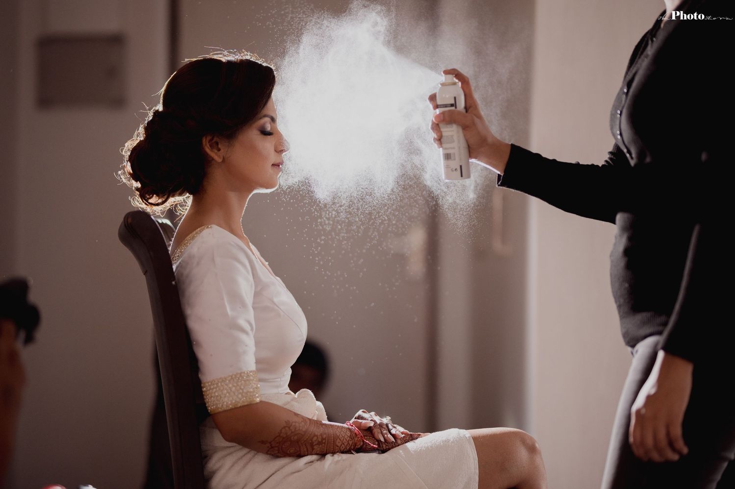 Artistic photo capturing hairspray moment during wedding preparations.