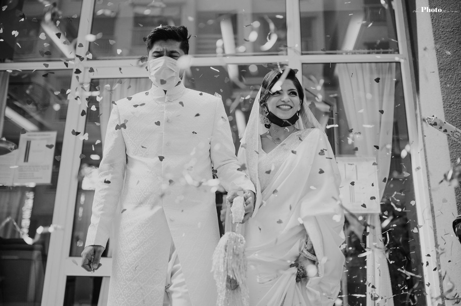 Black and white photo of wedding celebration with confetti falling.