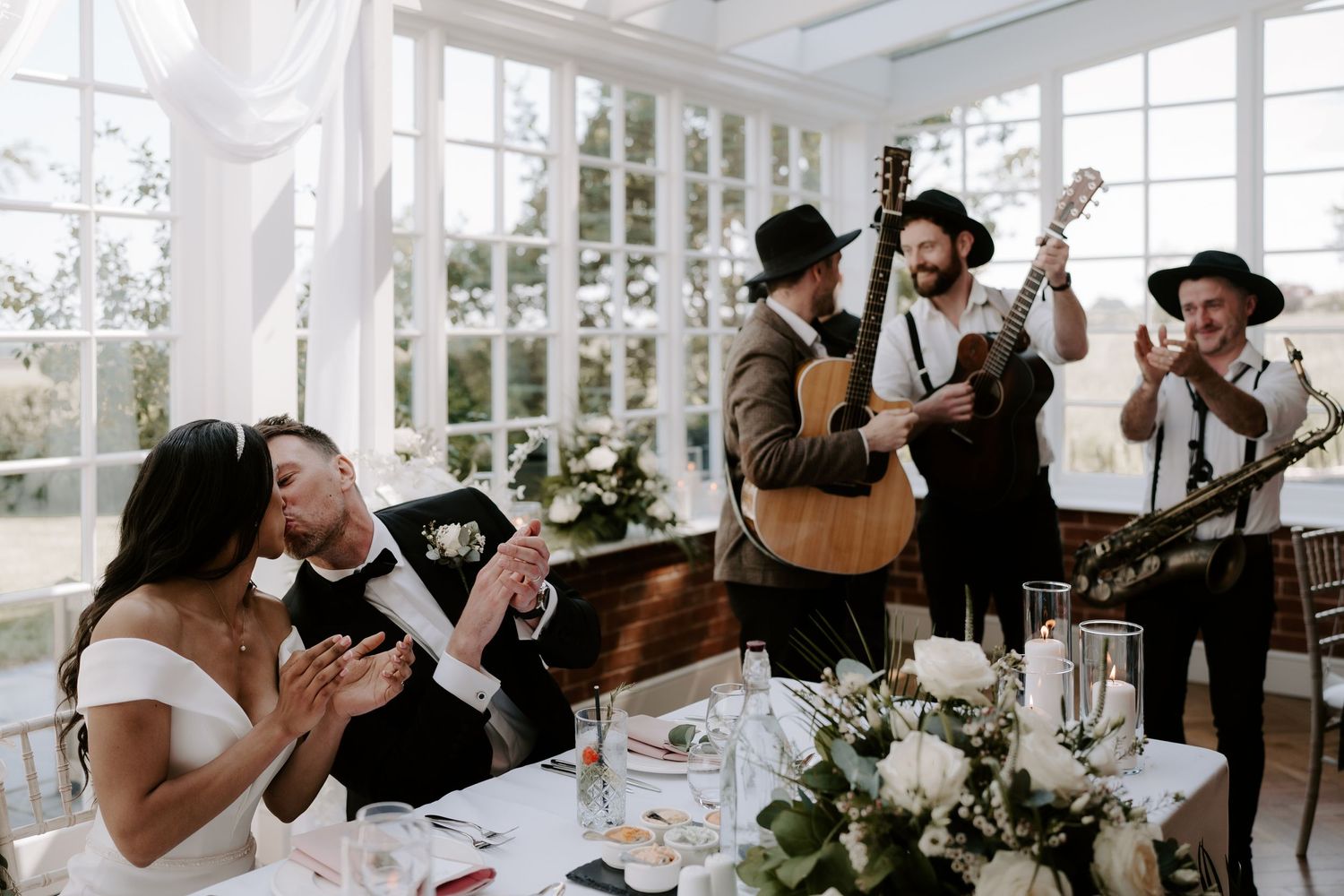 band-serenading-bride-and-groom-kissing-stockton-house-wedding-shropshire