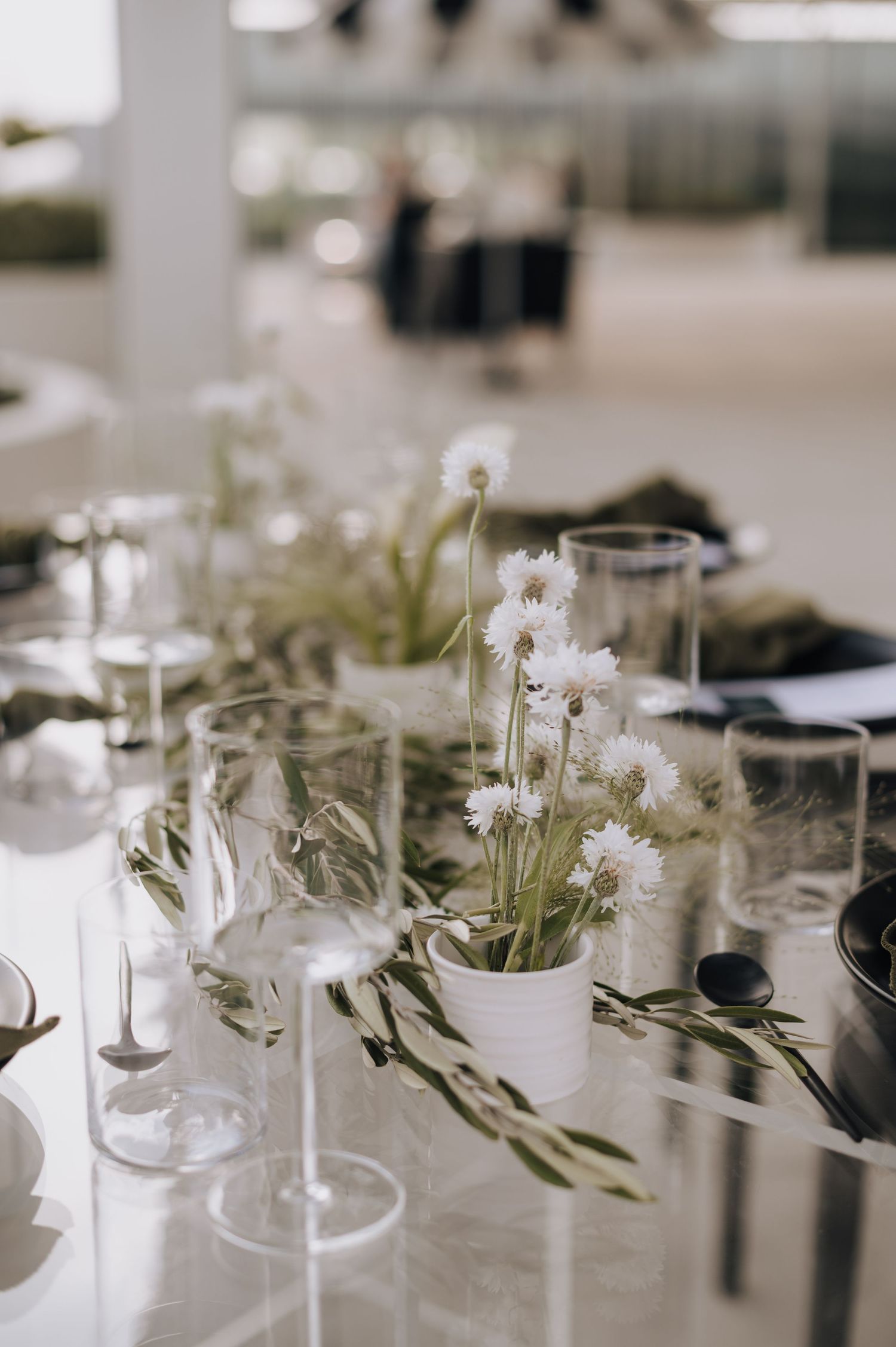 Wedding reception table decorated with delicate white flowers and glassware.
