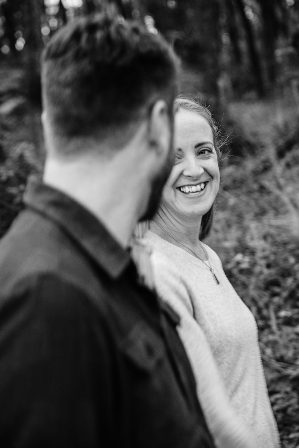 Intimate black and white portrait of couple sharing a tender moment outdoors.
