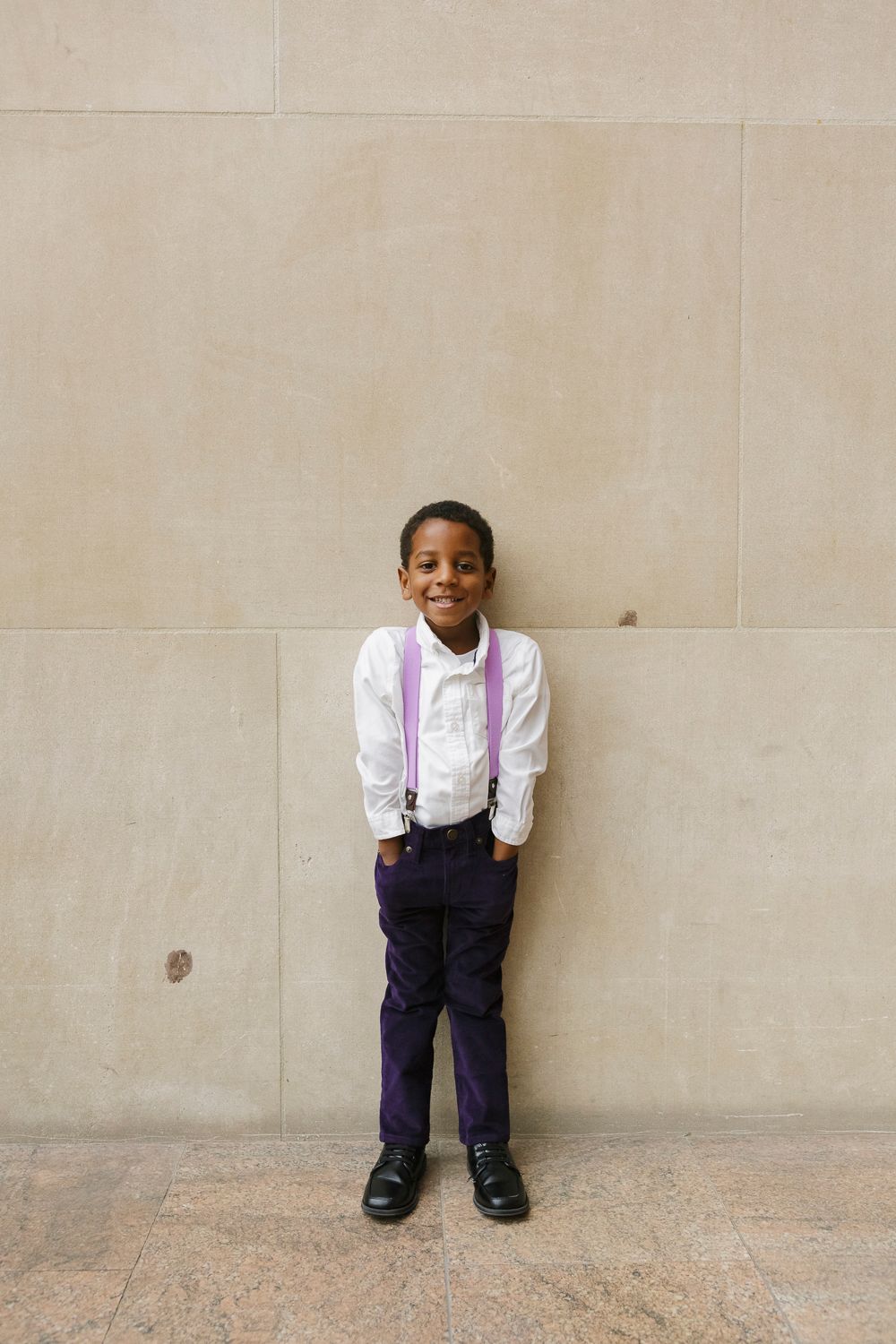 Cheerful young boy smiling brightly at The Met, photographed by Paula Ortiz during a family session