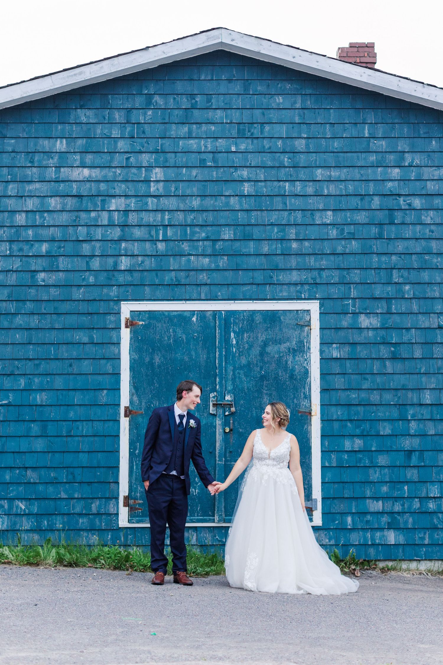Wedding couple poses against a rustic blue building exterior in a romantic photo sequence.