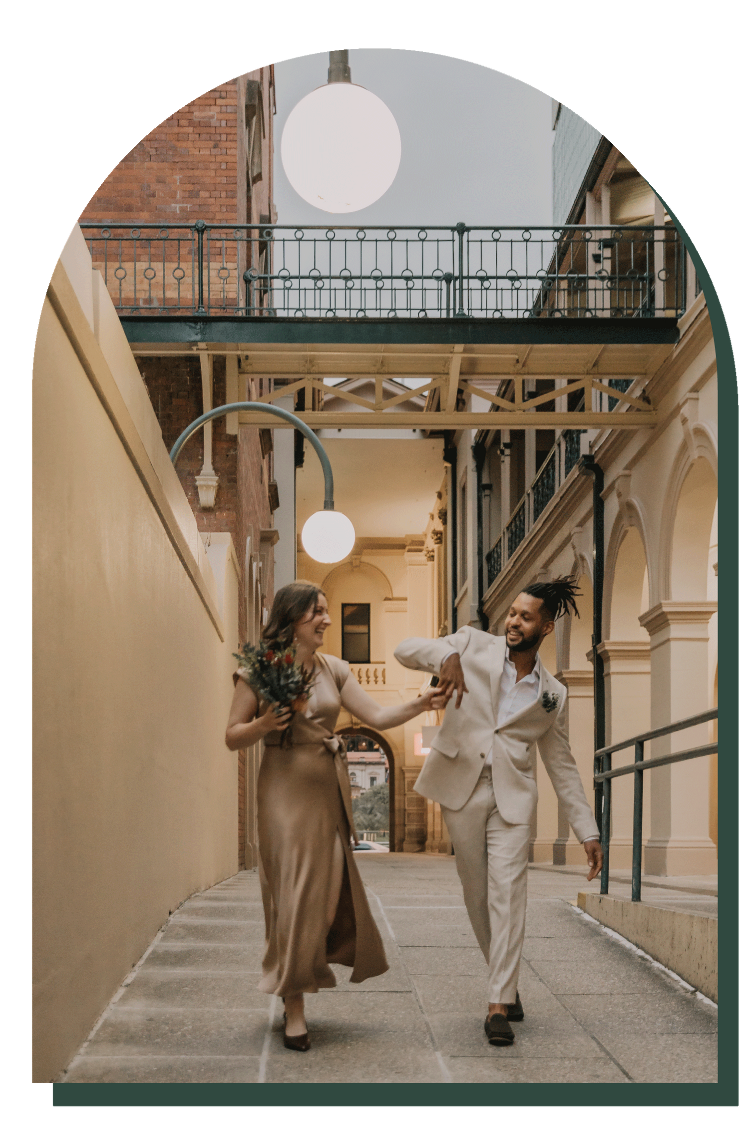 Couple walking together through an elegant architectural corridor with arched ceilings and vintage railings.