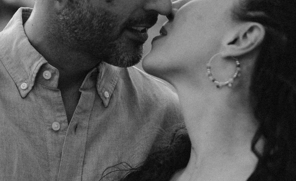 Black and white close-up photo of a couple sharing an intimate kiss.