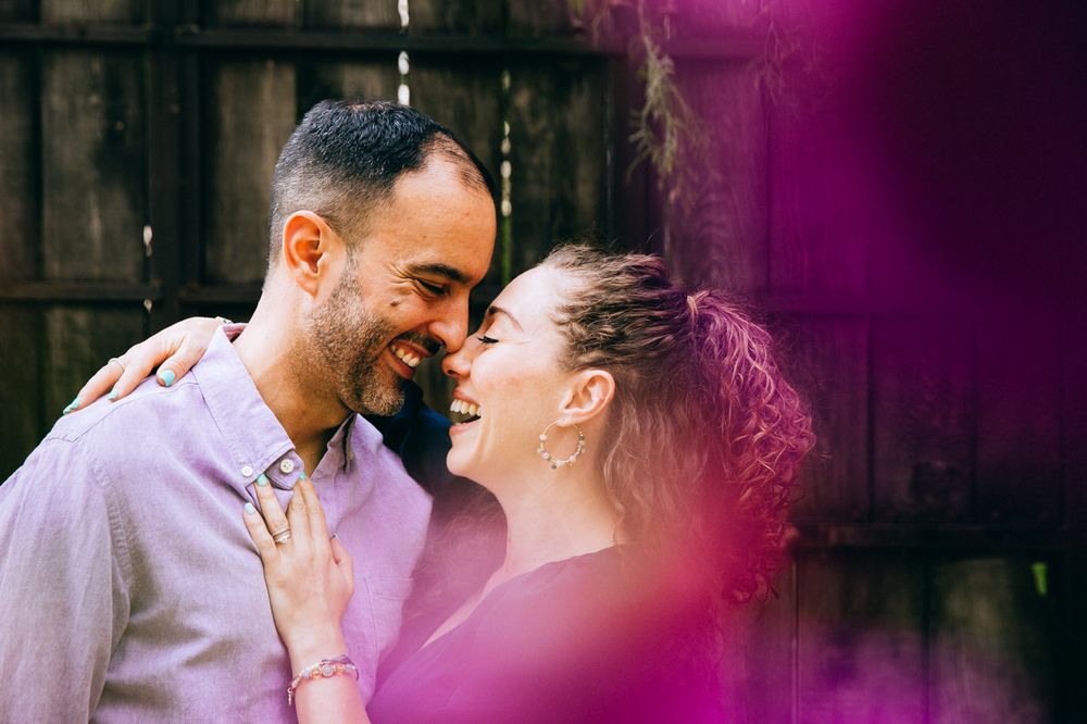 A joyful embrace captured through purple light effects against a wooden background.