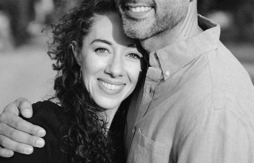 Black and white portrait of a joyful couple embracing and smiling.