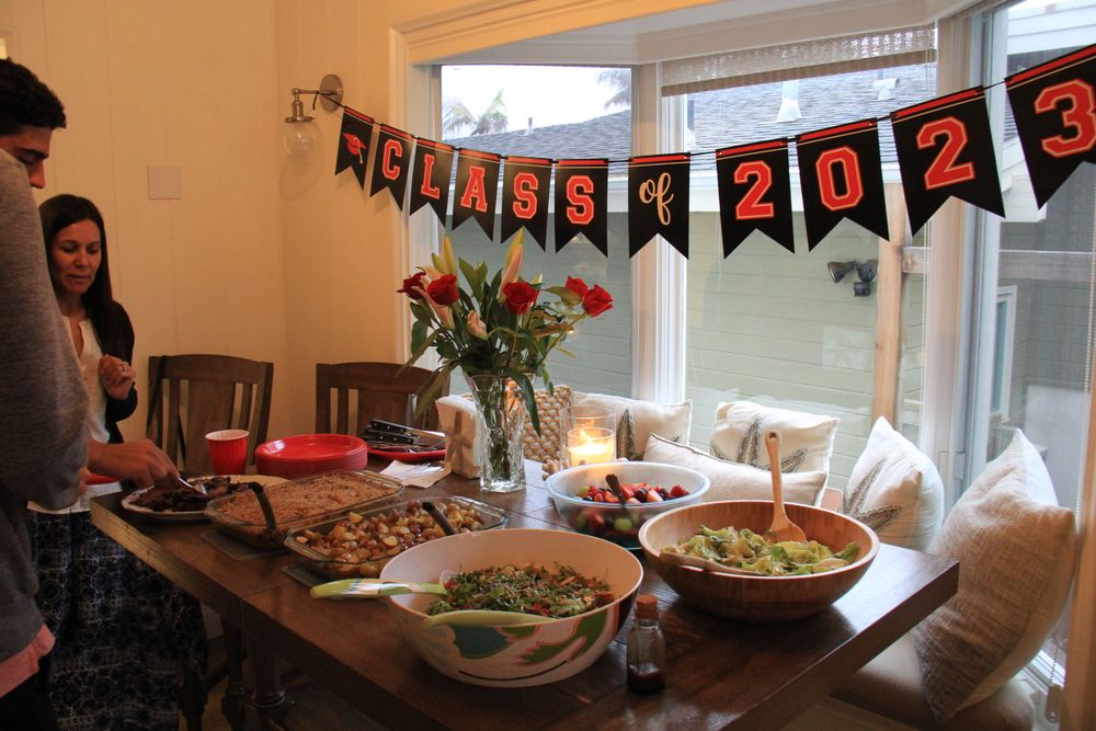 Celebration table setup with food and decorative banner reading 2023.
