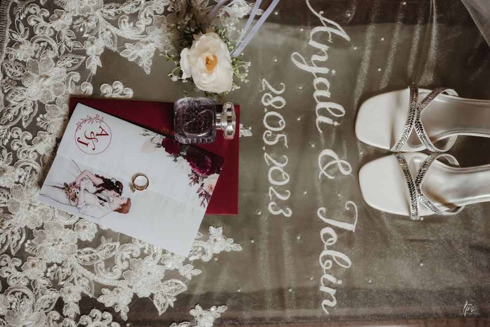 Wedding details and decorations arranged on a dark surface with floral elements.