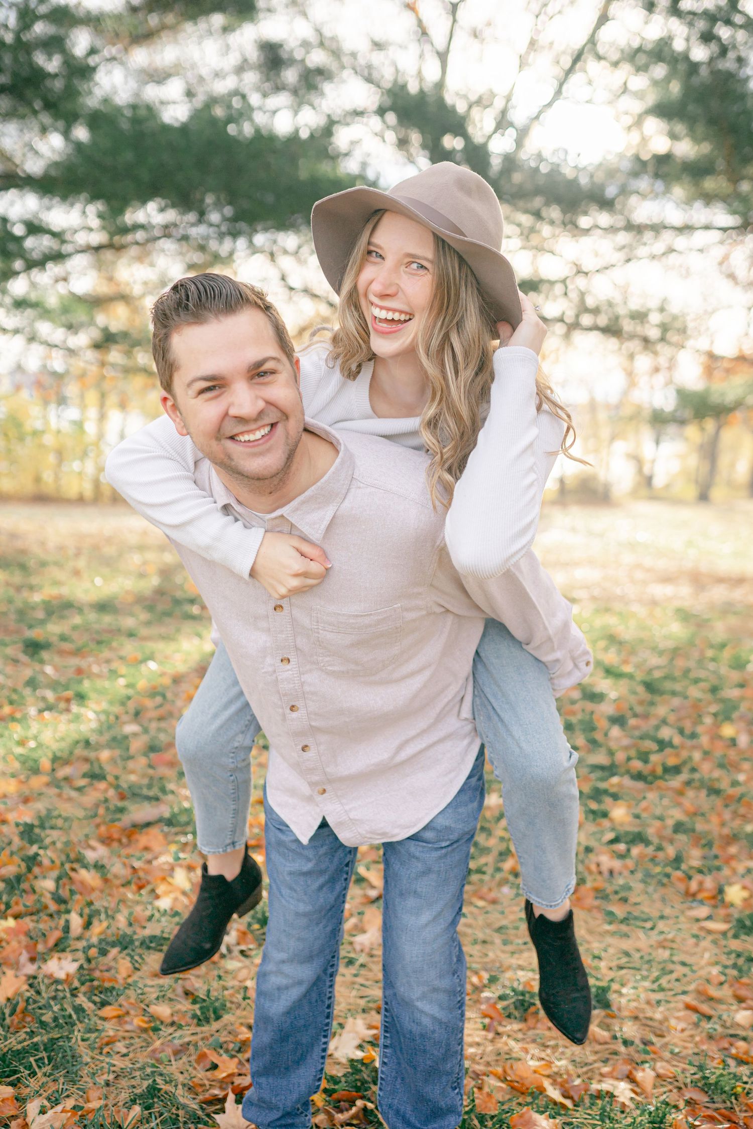 A couple embracing and smiling at each other in a scenic outdoor setting.