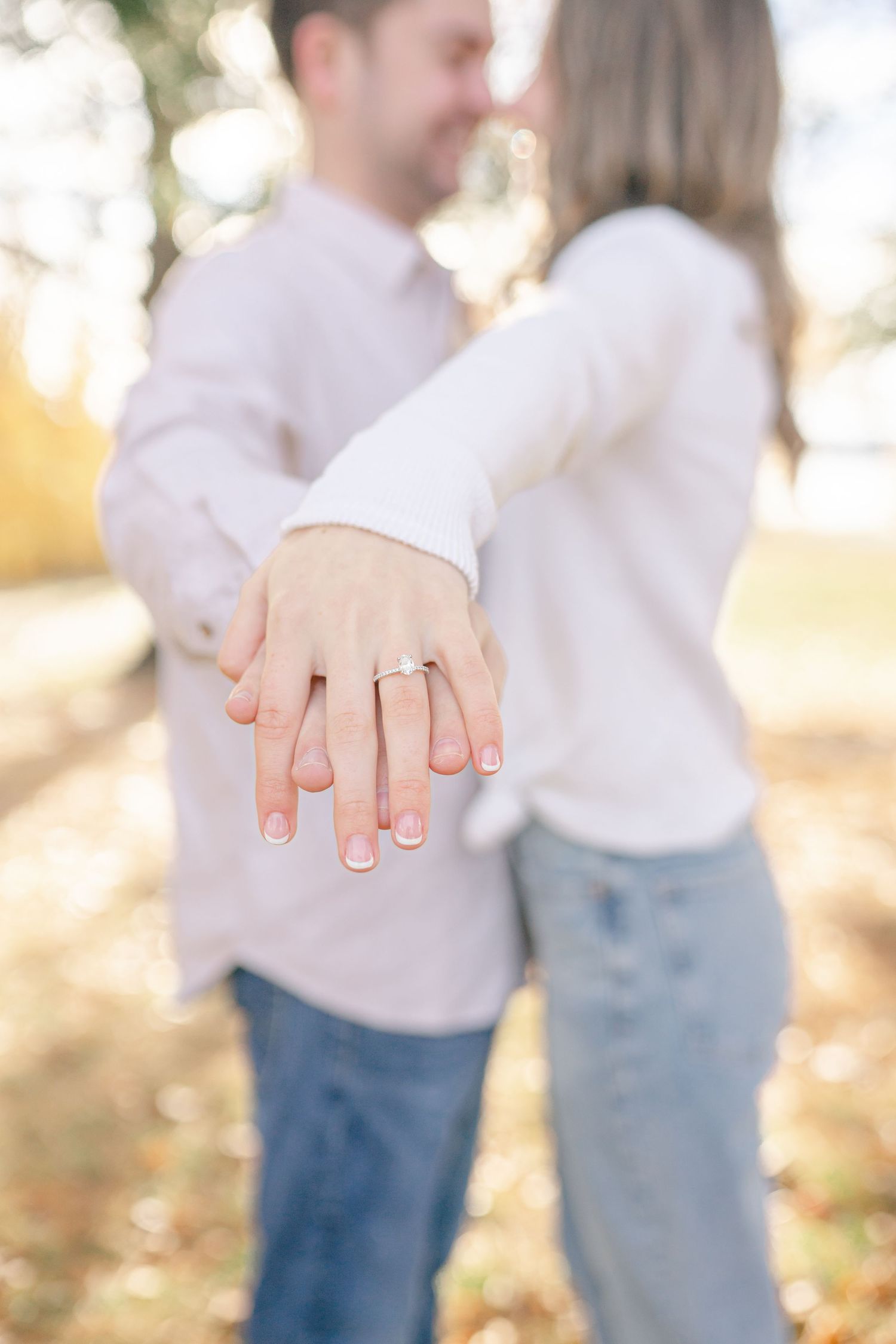 A couple holding hands and embracing in a scenic outdoor setting.