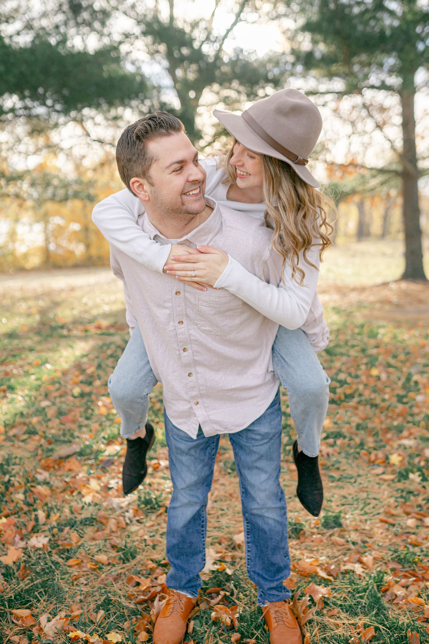 A couple embracing and looking at each other affectionately in a scenic outdoor setting.