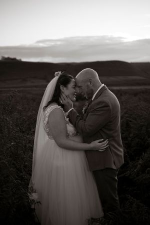 black and white portrait of a groom embracing his bride in the North York Moors, Ryedale Folk Museum