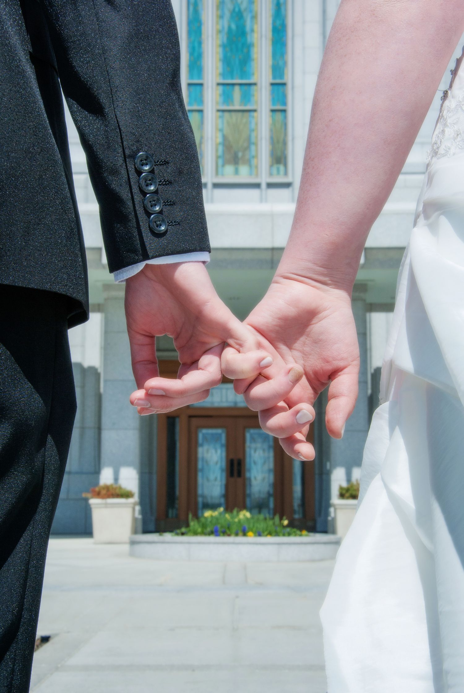 Calgary-mormon-wedding.jpeg, lds couple pinky swear in front of Calgary LDS Temple