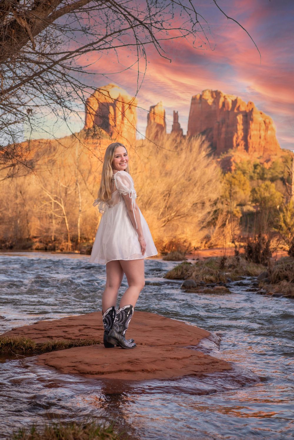 Scenic view of red rock formations at sunset with flowing river and desert vegetation in the foreground. Senior Portrait Photography Sedona
