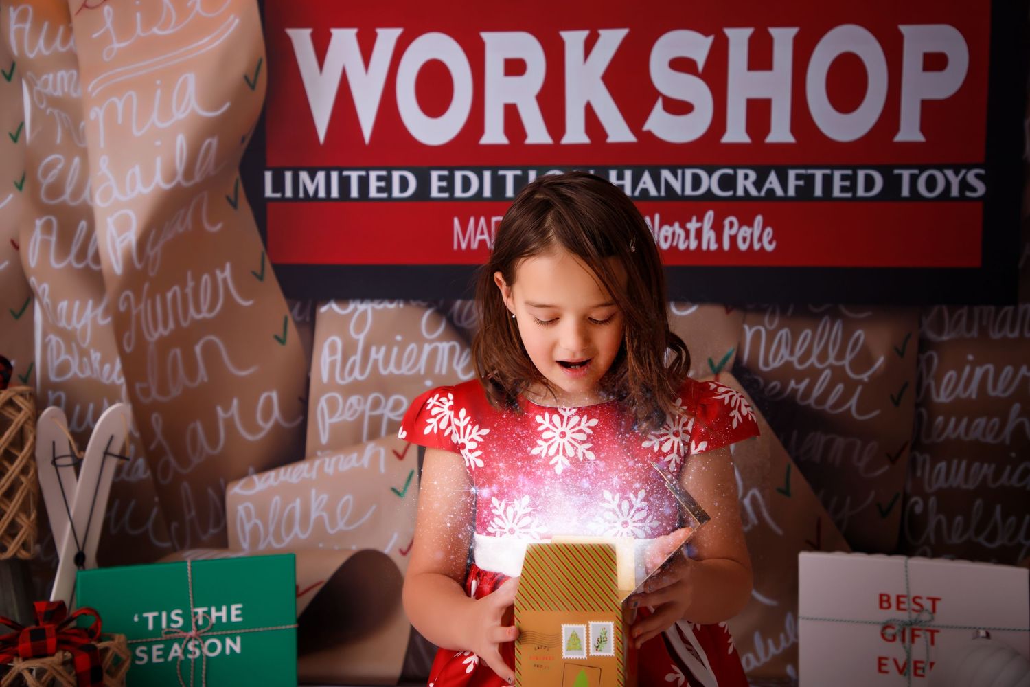 Magical holiday scene with glowing gift box and workshop sign in background.