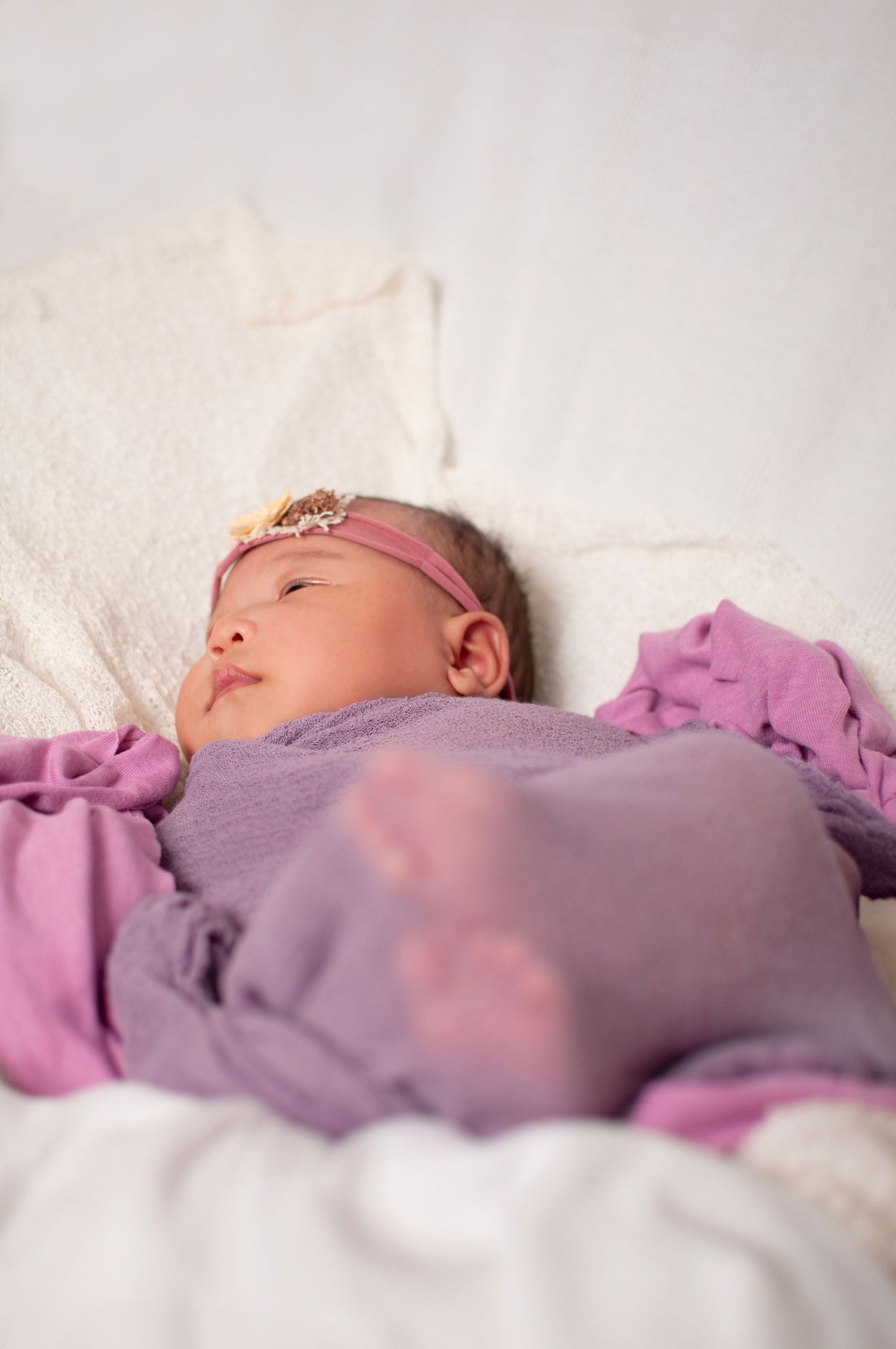 artistic pink and purple newborn wrap pose girl