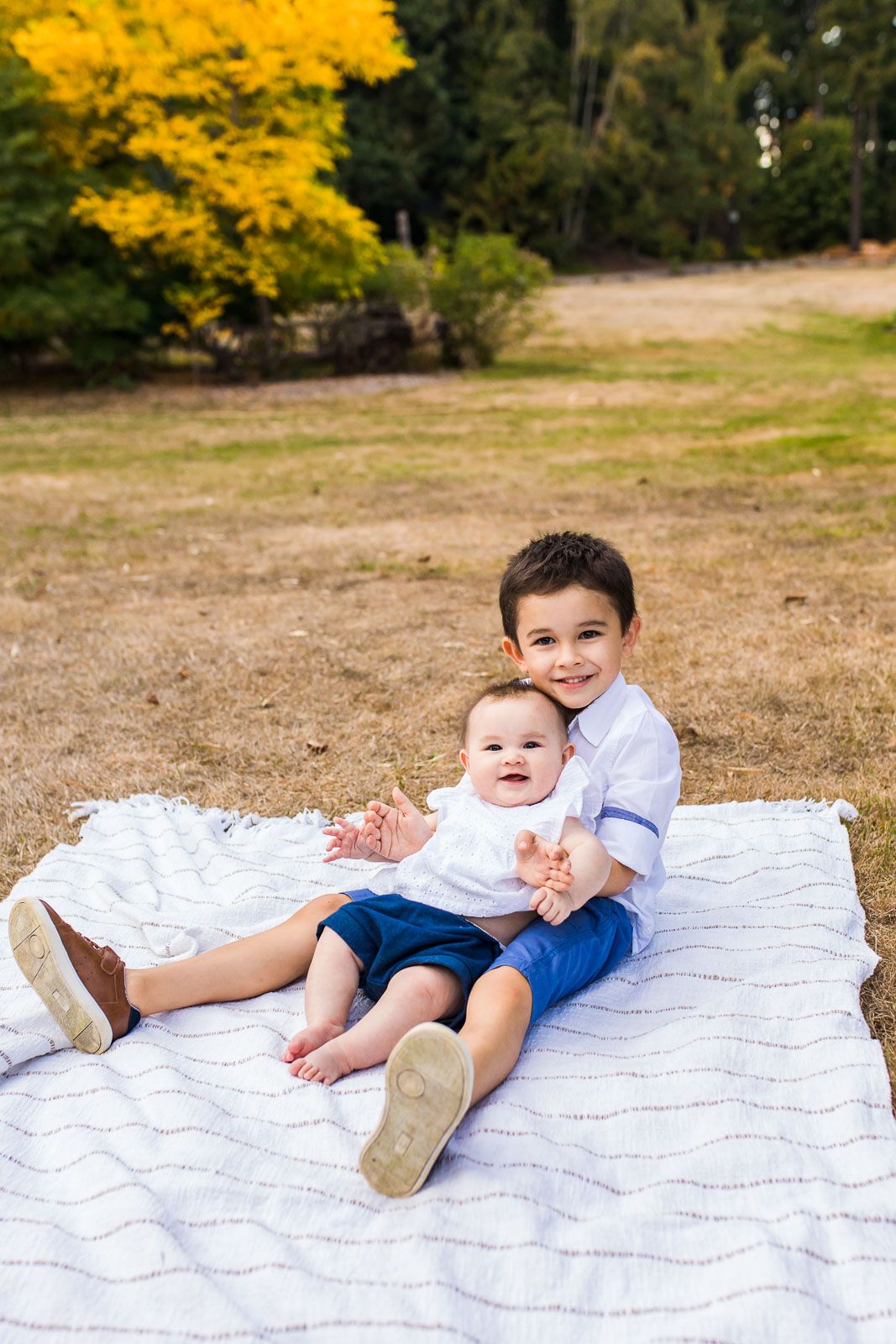 Kirkland family photographer captures tender sibling moment on a blanket in Kirkland