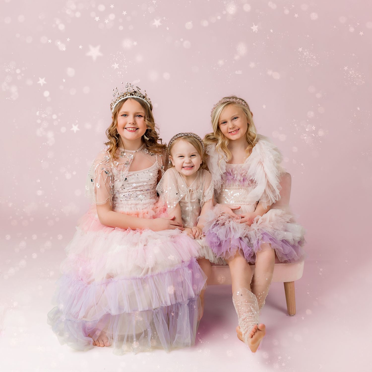 three little girls dressed in dresses and tiaras