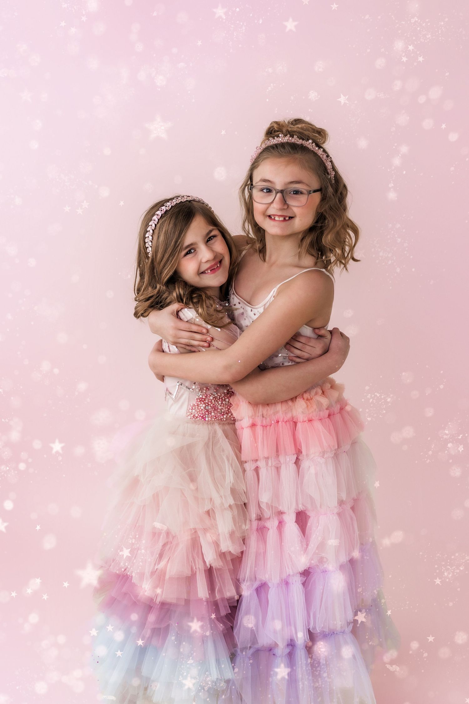 two sisters hugging with glitter background