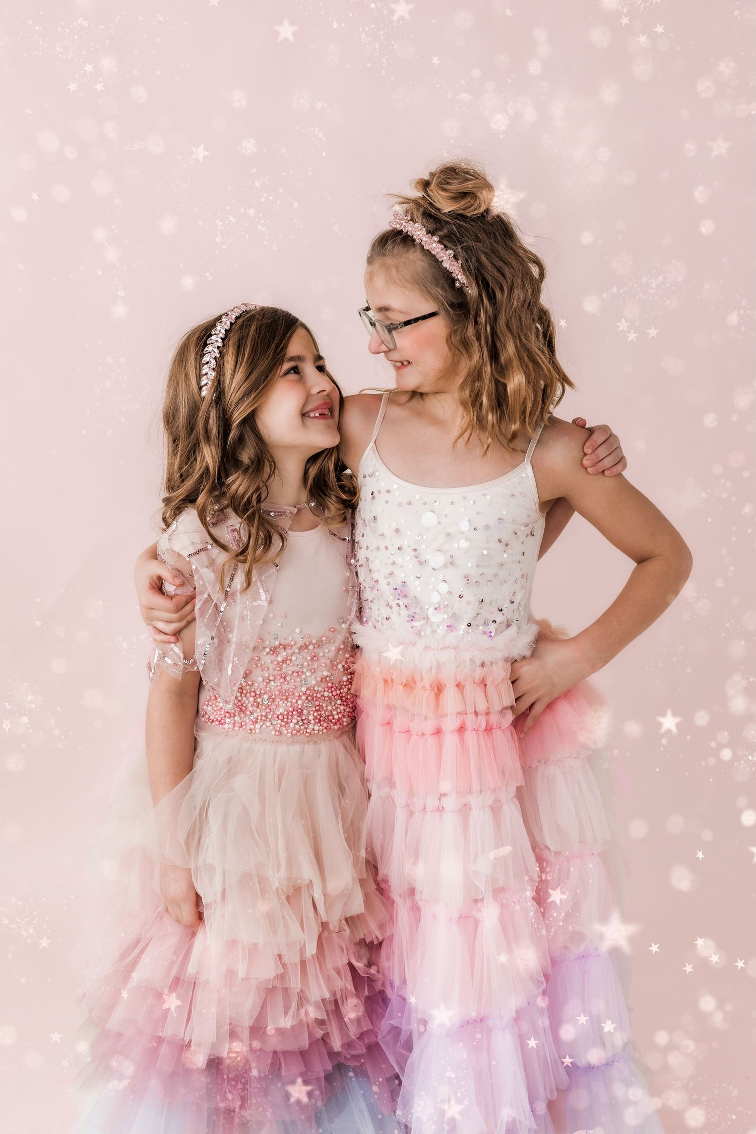 sisters looking at each other smiling with glitter all around